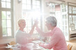 © KOTO - Business people high fiving at home office desk