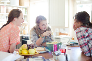 Wall Mural - Teenage girls learning at table in kitchen