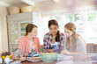 Teenage girls learning at table in kitchen