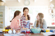 Teenage girls learning at table in kitchen