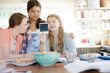 Three teenage girls looking at photograph while sitting at table