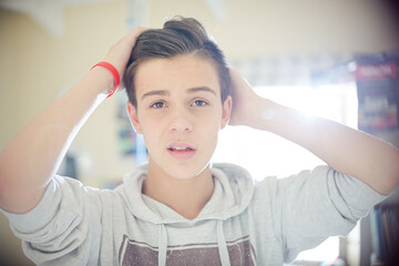 Portrait of teenage boy with hand in hair