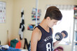 Teenage boy exercising with dumbbell