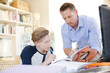 © KOTO - Father helping teenage son doing his homework in room