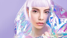 Cool Fashion Young Blond Girl With  Lavender Hair And Perfect Makeup, Healthy Glowing Skin In Colorful Iridescent Foil On Purple Background