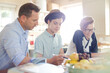 © KOTO - Teenage boys with father using laptop in dining room