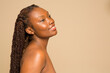 © Phiwo Ndlovu/Cultura Creative - Studio portrait of smiling shirtless woman with braided hair