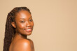 © Phiwo Ndlovu/Cultura Creative - Studio portrait of smiling shirtless woman with braided hair