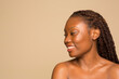 © Phiwo Ndlovu/Cultura Creative - Studio portrait of smiling shirtless woman with braided hair