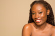 © Phiwo Ndlovu/Cultura Creative - Studio portrait of smiling shirtless woman with braided hair