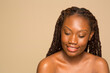 © Phiwo Ndlovu/Cultura Creative - Studio portrait of smiling shirtless woman with braided hair