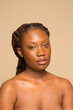 © Phiwo Ndlovu/Cultura Creative - Studio portrait of shirtless woman with braided hair