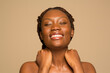 © Phiwo Ndlovu/Cultura Creative - Portrait of smiling woman touching neck