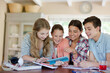© KOTO - Group of smiling teenagers taking selfie in dining room