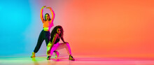 Two Beautiful Stylish Hip-hop Female Dancers On Colorful Gradient Background In Neon Lights