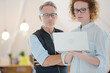 © KOTO - Portrait of man and woman with laptop, smiling in office