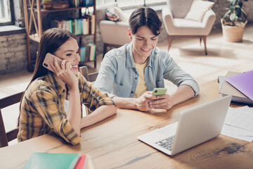 Poster - Portrait of two handsome beautiful cheerful learners using device chatting calling at library loft industrial interior indoors