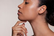 © Elle Bramble/Cultura Creative - Side view of young woman touching chin