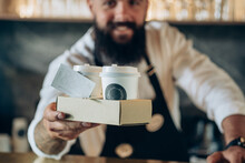 An Anonymous Barista Serving Two Take Away Paper Cup With Espresso To You.

Smiling Waiter Giving Disposable Tray With Two Cups Of Take Out Coffee With Loyalty Card In A Coffee Shop, Focus On Hands.