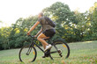 © PhotoAlto - Young man riding a bicycle in forest