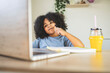 © PintoArt - little boy doing homework at home holding pencil looking at laptop