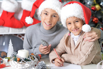 Canvas Print - Close up portrait of brother and sister preparing for Christmas