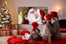 Family Watching TV Movie In Room Decorated For Christmas