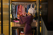 © IndiaPix - Young newlywed woman picking clothes from her closet.