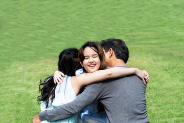 Happy cute daughter hugging daddy and mom love isolated on green. Portrait of a happy family of three. Happy family is having fun outdoors. Father, mother and girl are spending time together