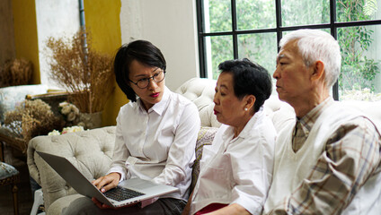 Asian advisor consultant to senior showing data through laptop discuss on plan investment and healthcare
