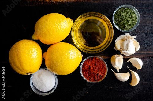 Lemon Garlic Marinade Ingredients on a Wood Table: Lemons, olive oil, and seasonings used to make a marinade