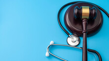 Healthcare Legislation And Regulation, Medical Malpractice Decision And Health Care Injury Personal Attorney Concept With Gavel And Stethoscope Isolated On Blue Background With Copy Space