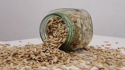 Sticker - Rotating shot of glass bottle filled with sunflower seeds