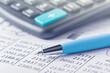 © evkaz - accounting document with pen and calculator. Concept of banking, financial report and financial audit.