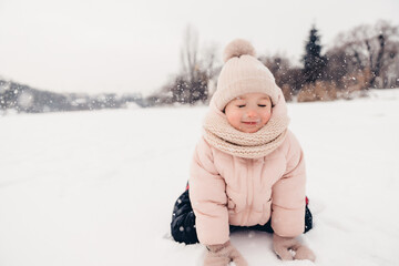 Canvas Print - Portrait of a girl playing in the snow during a winter walk and playing snowballs, rolling and skating in the snow