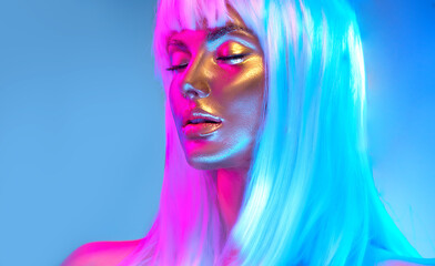 Wall Mural - Glowing gold skin. Fashion model woman face in bright neon colourful lights, beautiful sexy woman with white hair and trendy make-up. Art design make up. Glittering, golden, metallic shine makeup