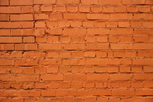 Brick Wall Painted With Orange Paint With Real Cracks And Dents