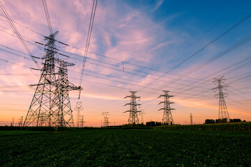 A silhouette of an electric tower against a beautiful sunset background