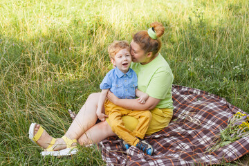 a heartfelt moment. portrait of a mother and her beloved son of European appearance with disabilities in a park on a summer day. Disability. Mother's love.