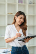 © PaeGAG - Young asian businesswoman using tablet with smiling face, positive emotion, at office, casual office life concept
