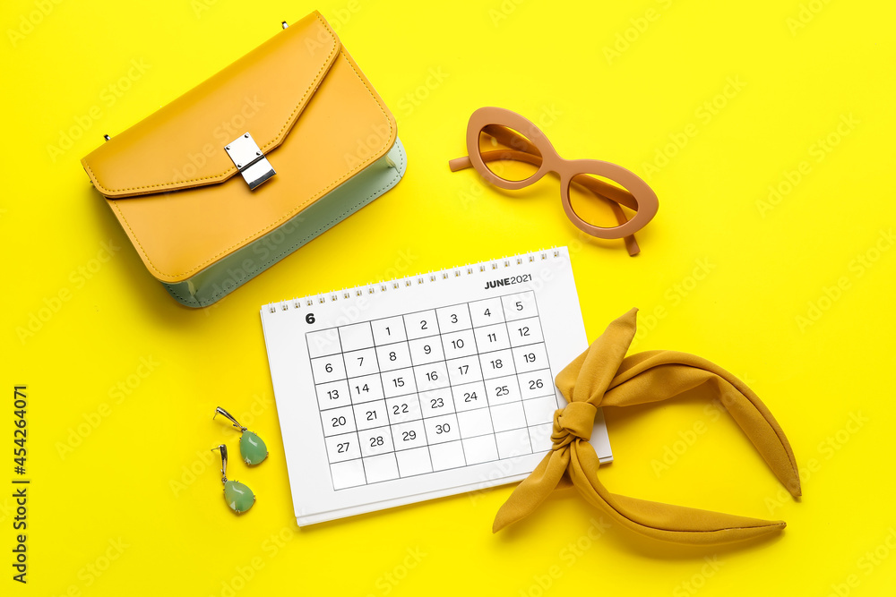 Calendar with female accessories on color background