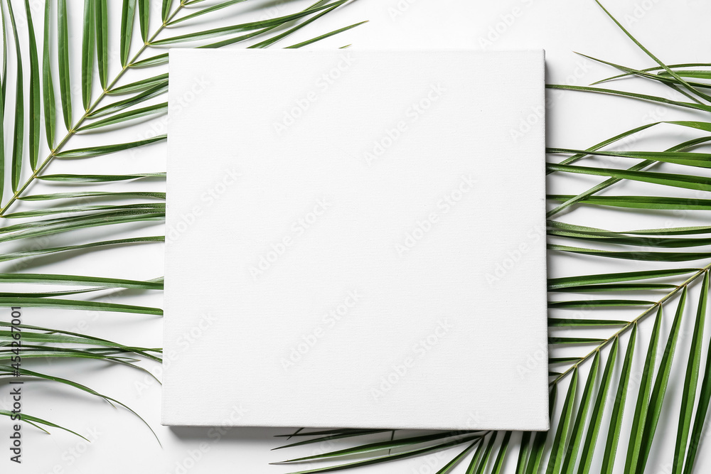 Blank poster and palm leaves on white background