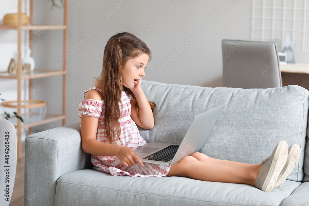 Surprised girl watching cartoons at home