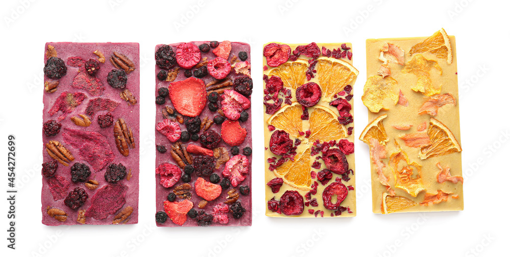Handmade chocolate bars with fruits, berries and nuts on white background