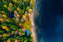 Aerial View Of Yellow And Orange Autumn Forest With  Cottage And Wooden Pier By Blue Lake.