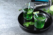 Delicious mint liqueur with green leaves and lime on grey table. Space for text