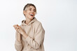 © Cookie Studio - Young natural woman laughing, smiling and looking aside, girl has nude makeup, clean healthy skin, stands against white background