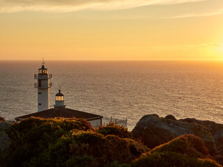 Wall Mural - Tourinan Lighthouse in Muxia, Galician coast, Spain. Twice a year, at the beginning of spring and the end of summer, Cape Touriñan becomes the last shadow for the sunset in continental Europe.