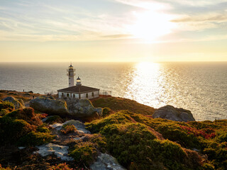 Wall Mural - Tourinan Lighthouse in Muxia, Galician coast, Spain. Twice a year, at the beginning of spring and the end of summer, Cape Touriñan becomes the last shadow for the sunset in continental Europe.