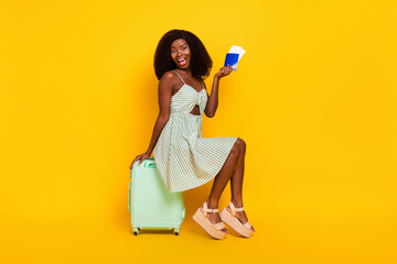 Wall Mural - Full body profile side photo of young excited black girl sit baggage ticket visa trip isolated over yellow color background